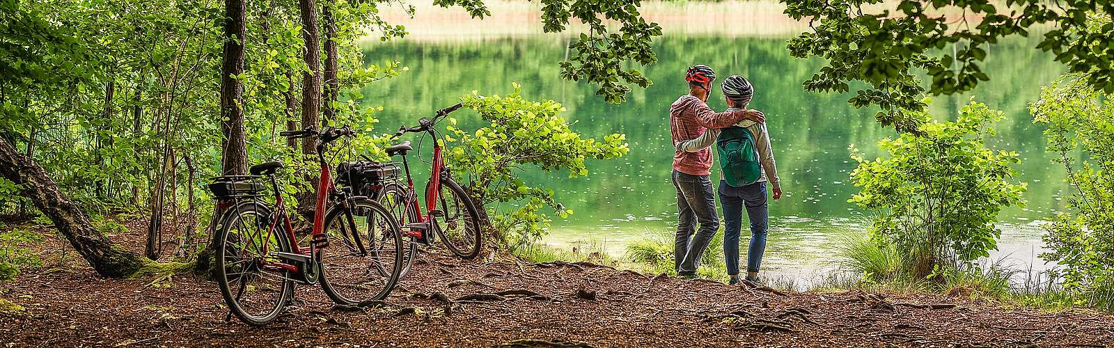 Radfahrer machen Pause und schauen auf den Trünnensee