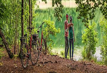 Radfahrer machen Pause und schauen auf den Trünnensee