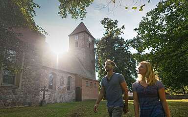 Besucher vor der alten Feldsteinkirche in Menz