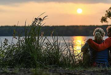 Paar genießt den Sonnenuntergang am Stechlinsee
