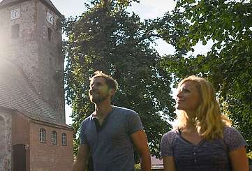 Besucher vor der alten Feldsteinkirche in Menz