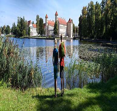 Besucher am Ufer des Grienericksees vor dem Schloss Rheinsberg