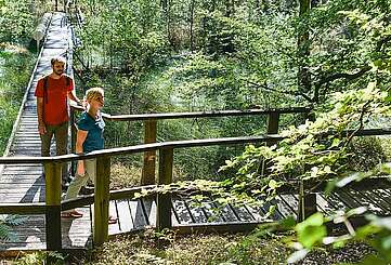 Besucher erkunden den Moorerlebnispfad bei Menz