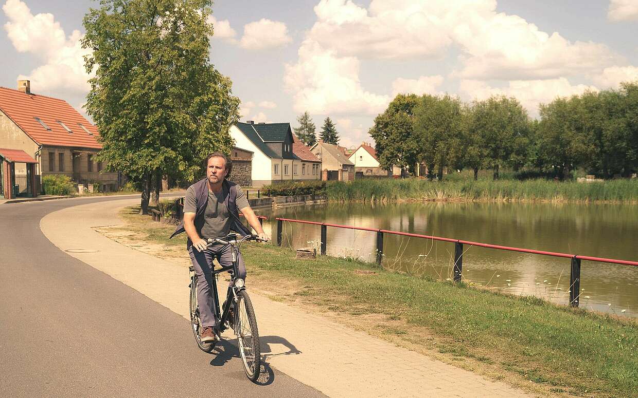 Schauspieler Bjarne Mädel auf Fahrrad in Beiersdorf-Freudenberg