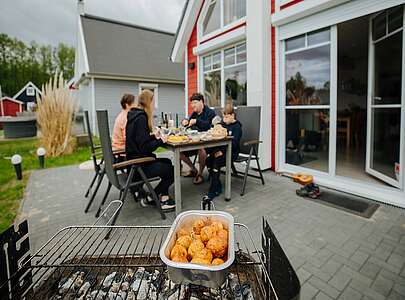Familie am Tisch hinter dem Grill im Hafendorf Zerpenschleuse