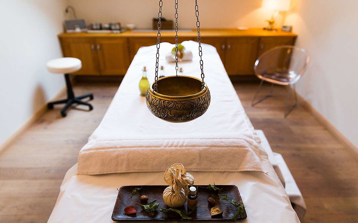 Massageliege mit Duftschale und Ölen